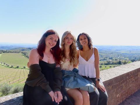Sarah with two other students in the program posing with a green landscape in the background