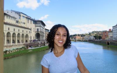 Sarah standing in front of a body of water in Italy