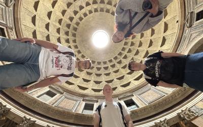 Low point of view photo of 4 college students in a Roman cathedral